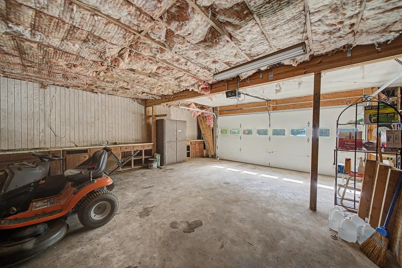 The basement garage with room for vehicles and a mower