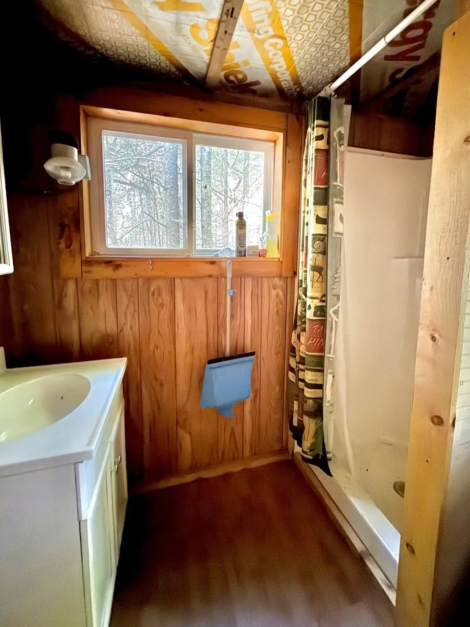 The bathhouse with the sink, the window and the shower stall