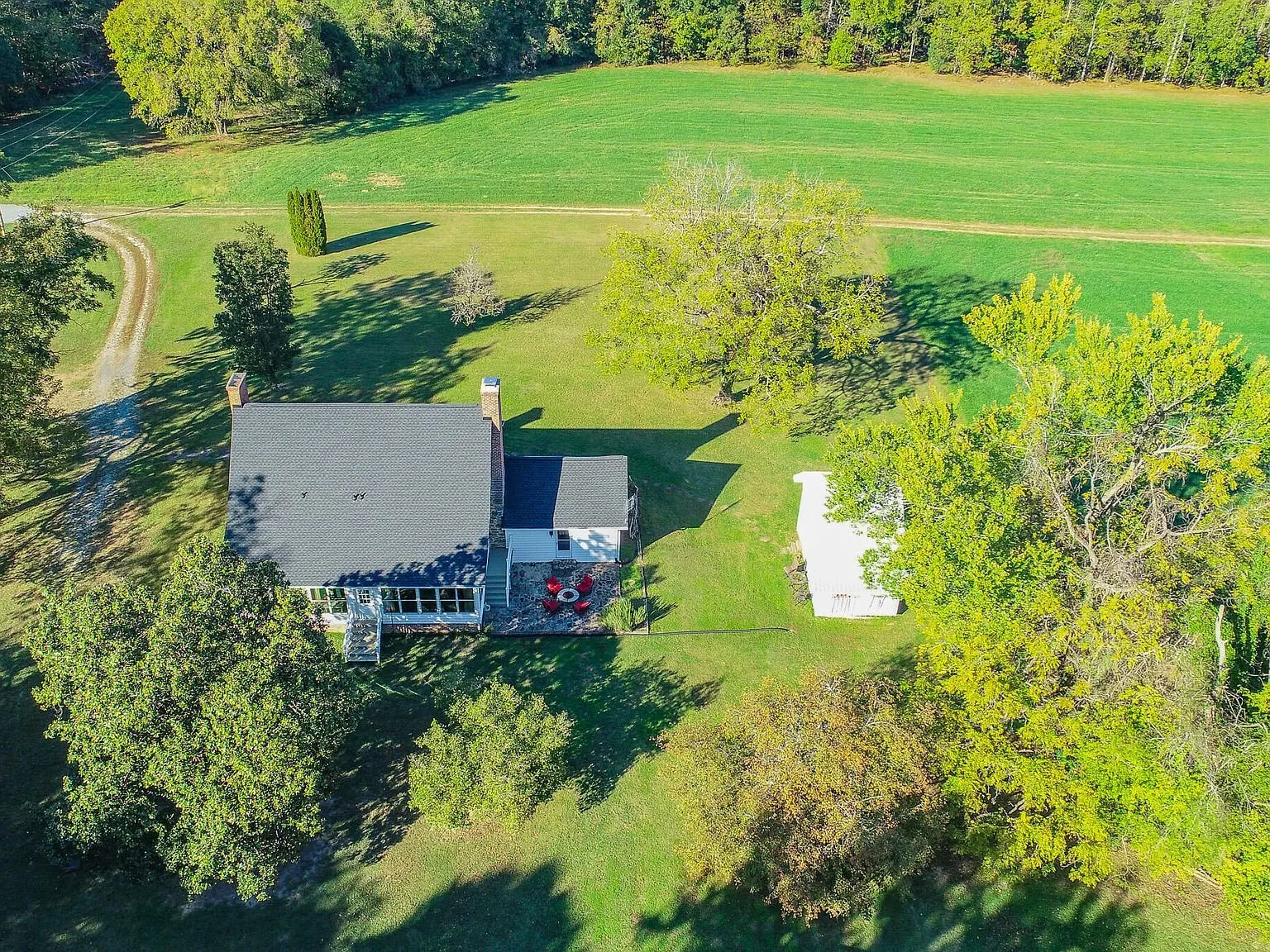 Aerial view of the farmhouse and detached structures surrounded by open field