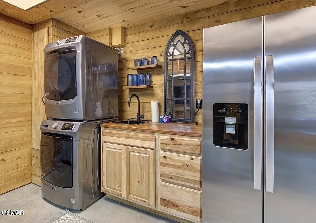 The lower level kitchenette with a stacked washer and dryer and a refrigerator