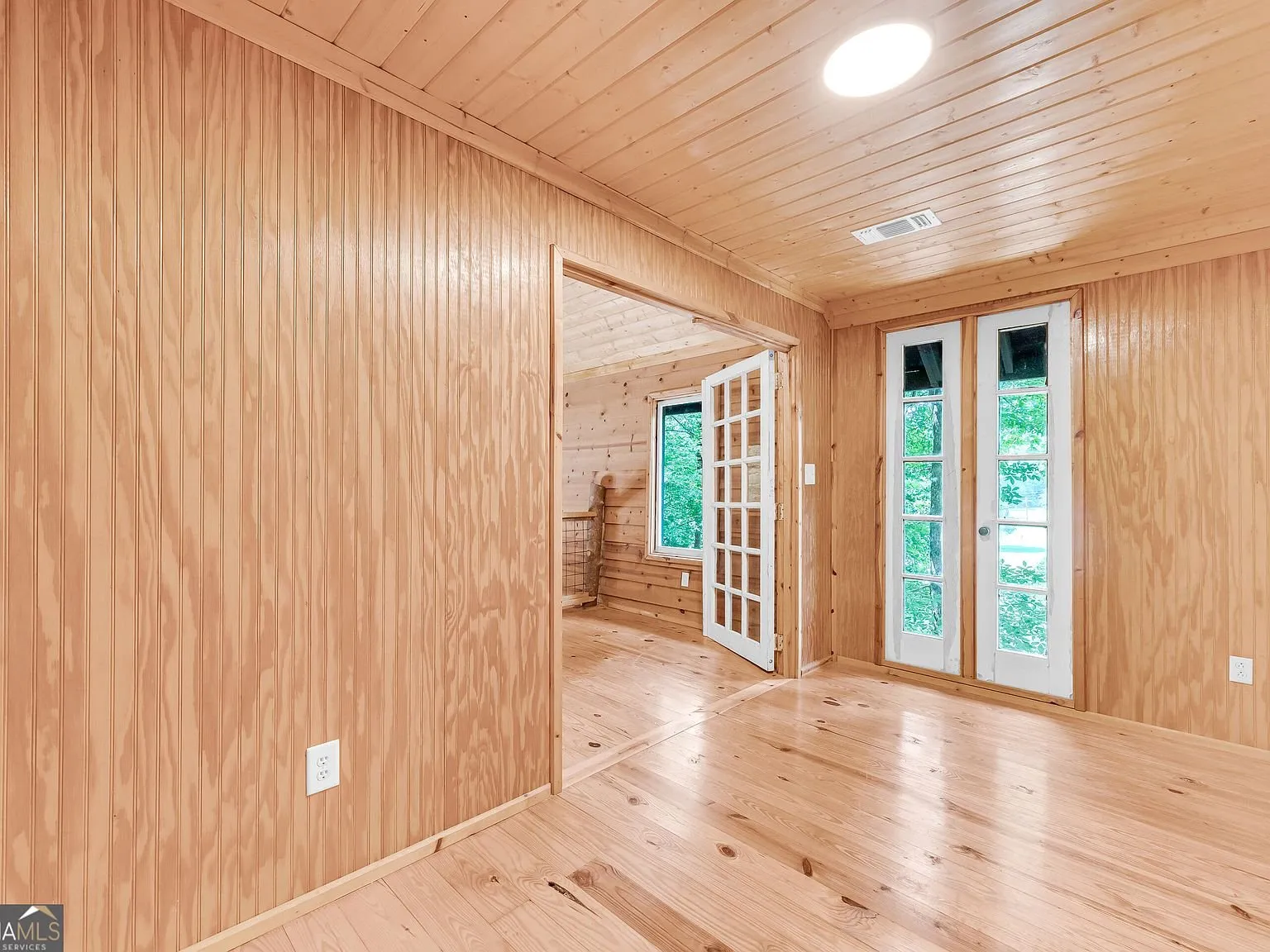 A second view of the upstairs French doors and wood flooring