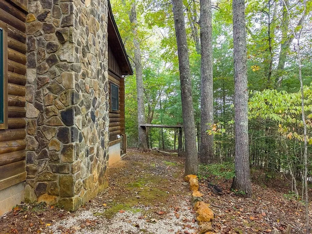The stone chimney and log siding at the base of the cabin