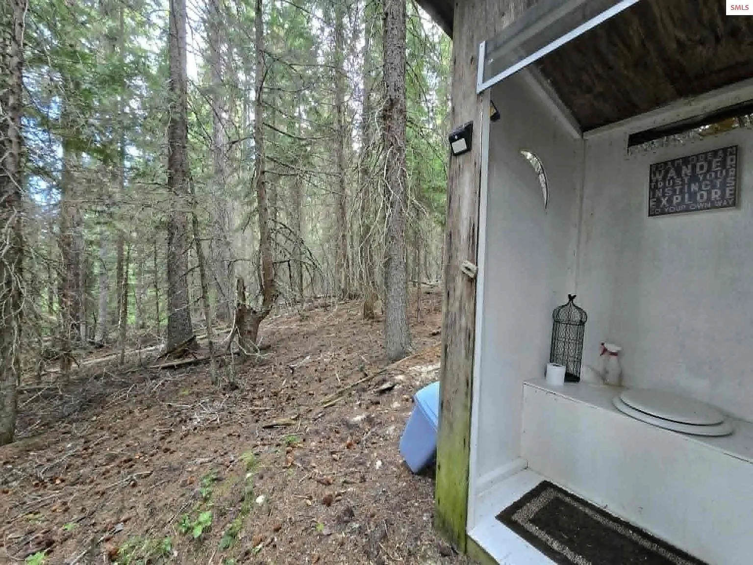 The outdoor outhouse structure, built into the hillside beside the cabin