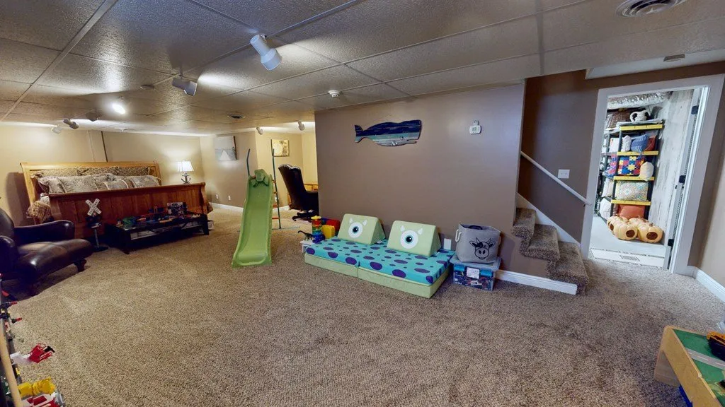 The finished basement set up as a playroom with a slide