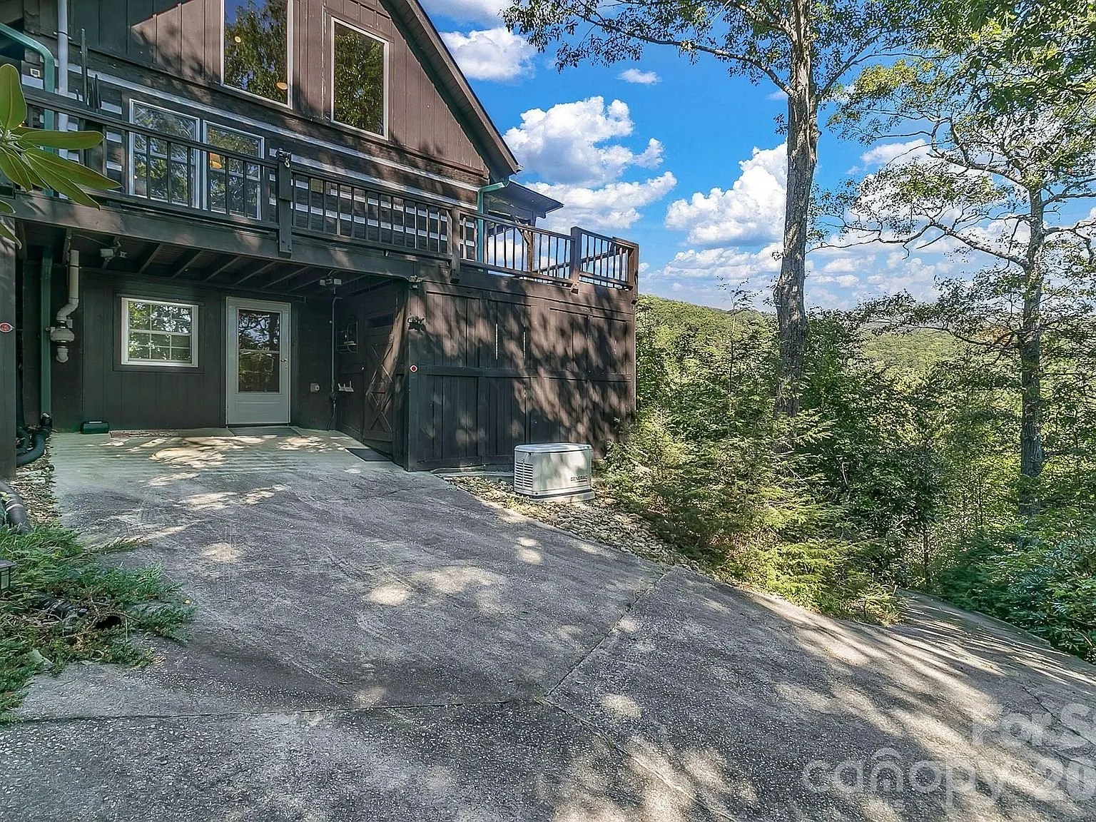 The lower-level carport and driveway area beside the cabin