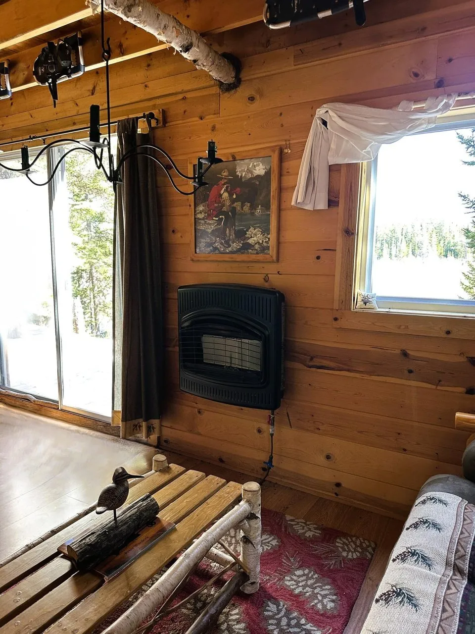The woodstove against the log wall under a window