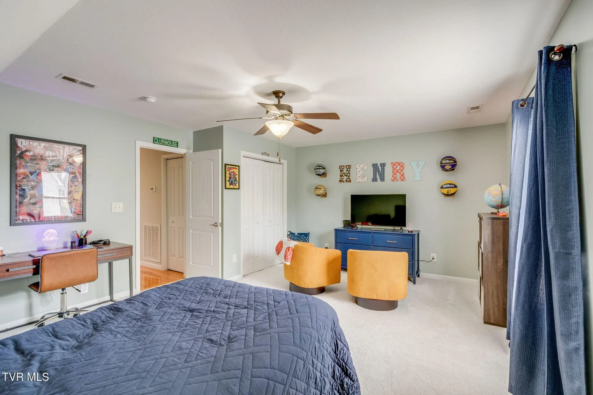 The same bedroom from the doorway with a desk under the window