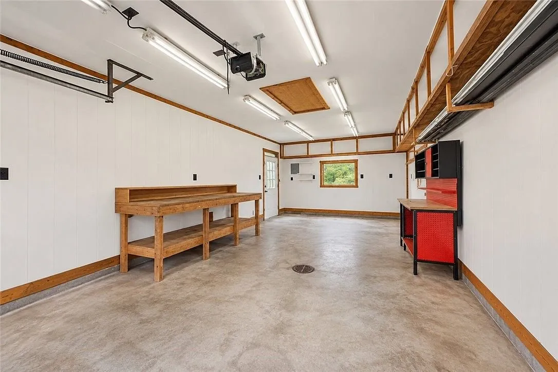 The garage floor and overhead lighting toward the garage door