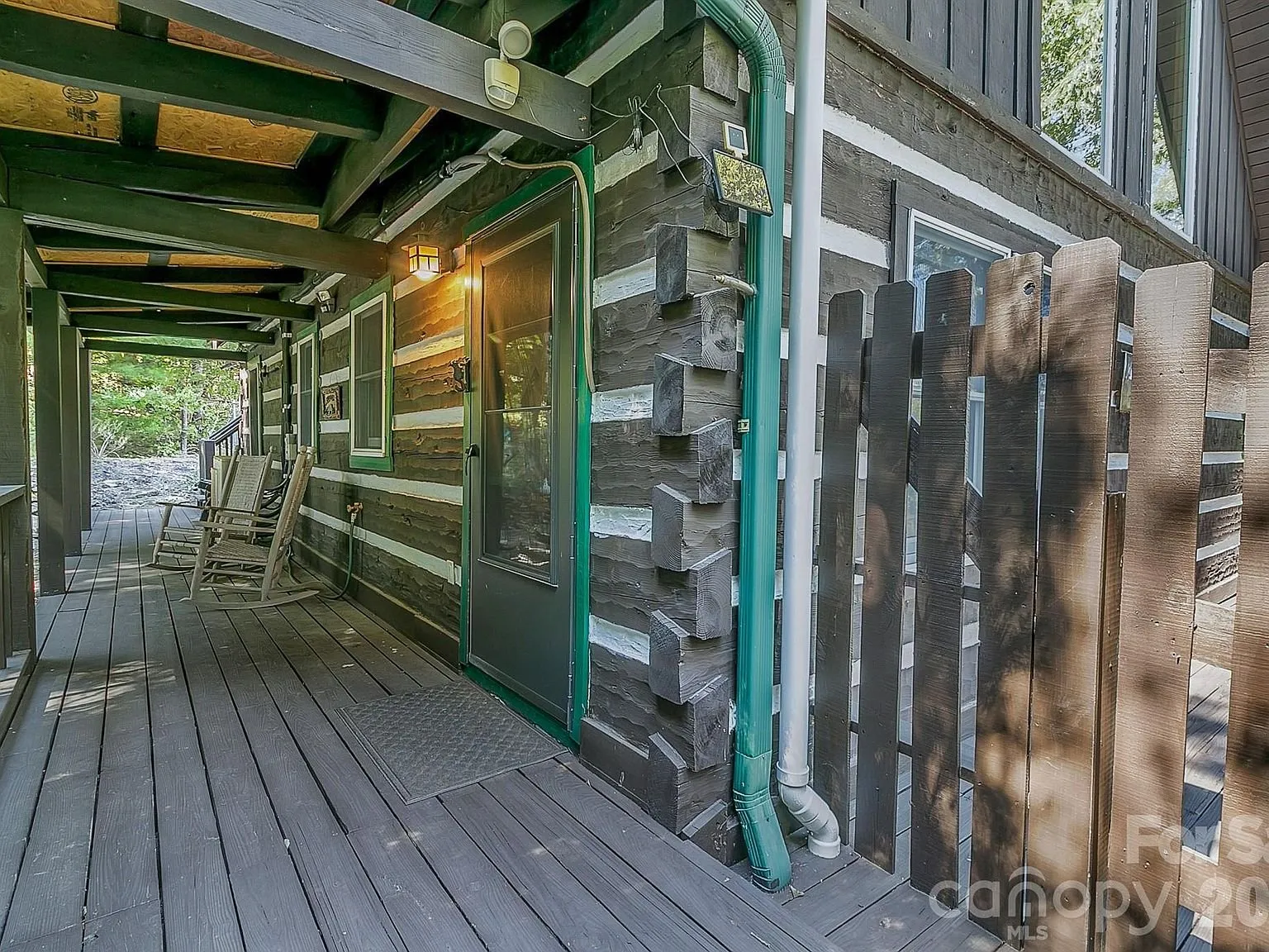 A covered walkway along the lower level of the cabin