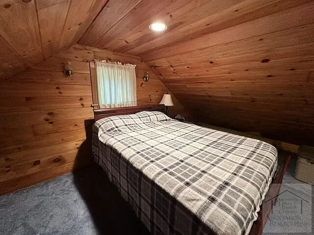 A bed in the sleeping loft under the sloped ceiling