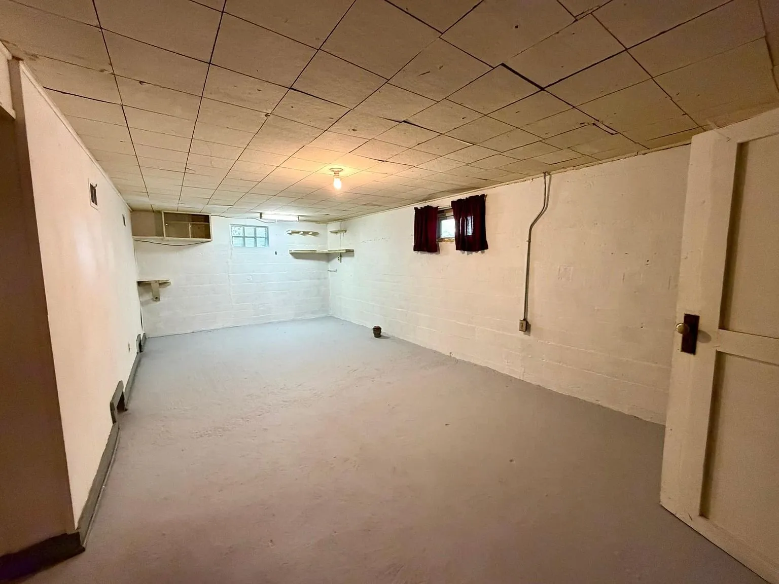 The unfinished basement with the block walls and the painted floor