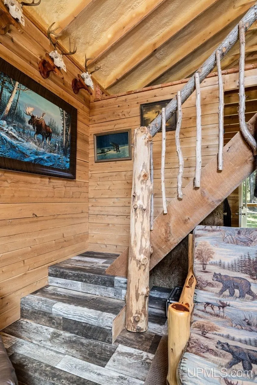The stairs running up to the loft along the log wall