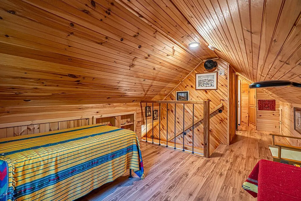 A wide view of the loft bedroom looking back toward the stairway rail