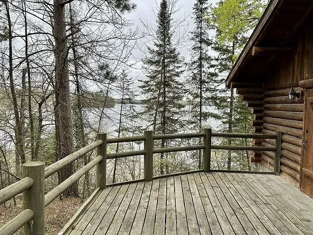 The deck rail with the lake through the pines
