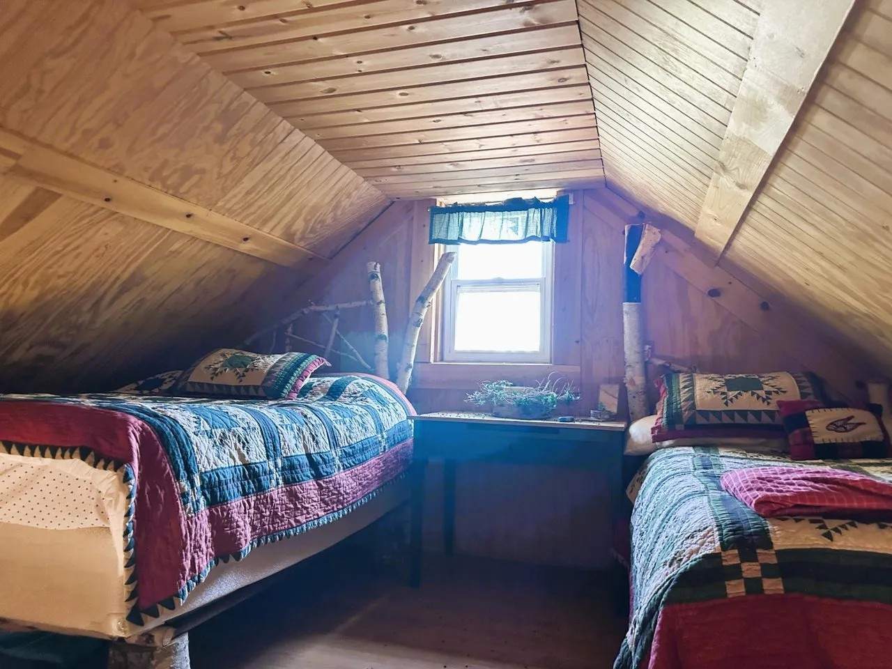 Two beds in the loft under the pine ceiling