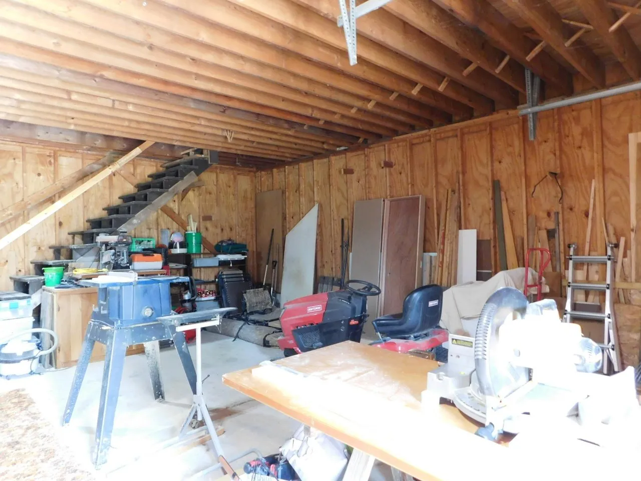 Inside the garage upper level with the stairs and workbenches
