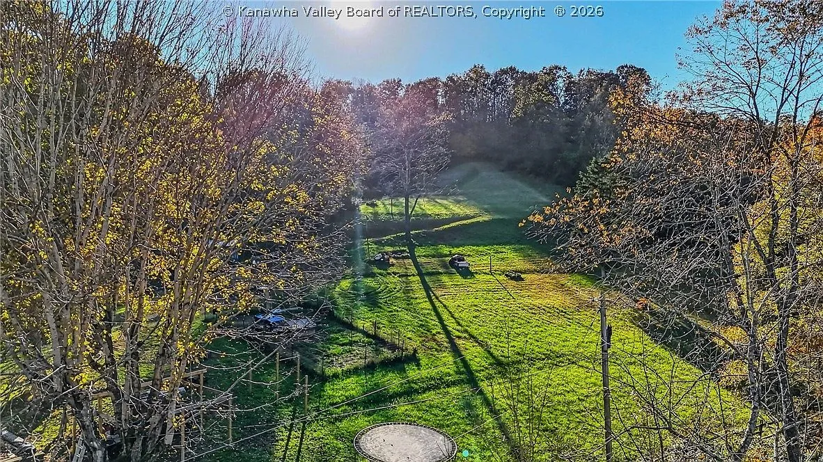 An aerial view of the backyard trampoline and sloped pasture at sunrise