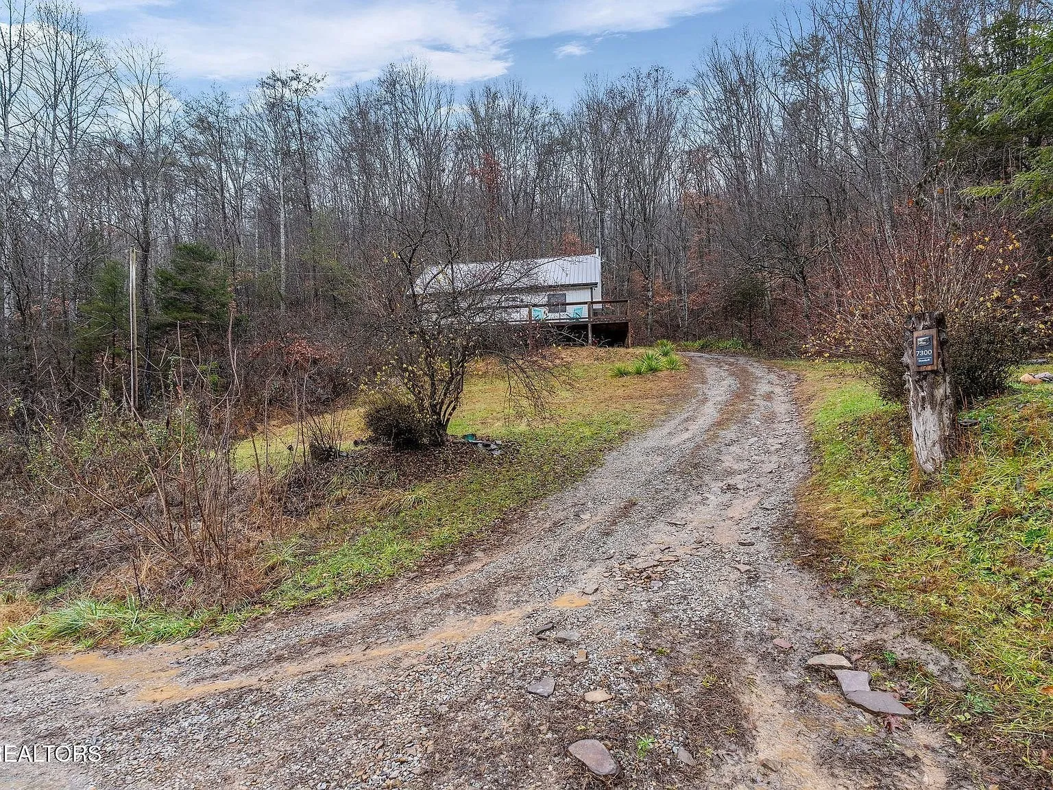 The home's long covered deck and dormer roofline from the hillside below