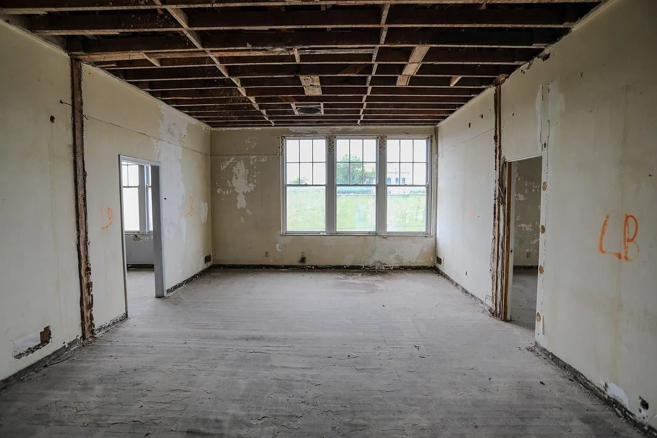 An upper floor room with the ceiling opened and windows at the end