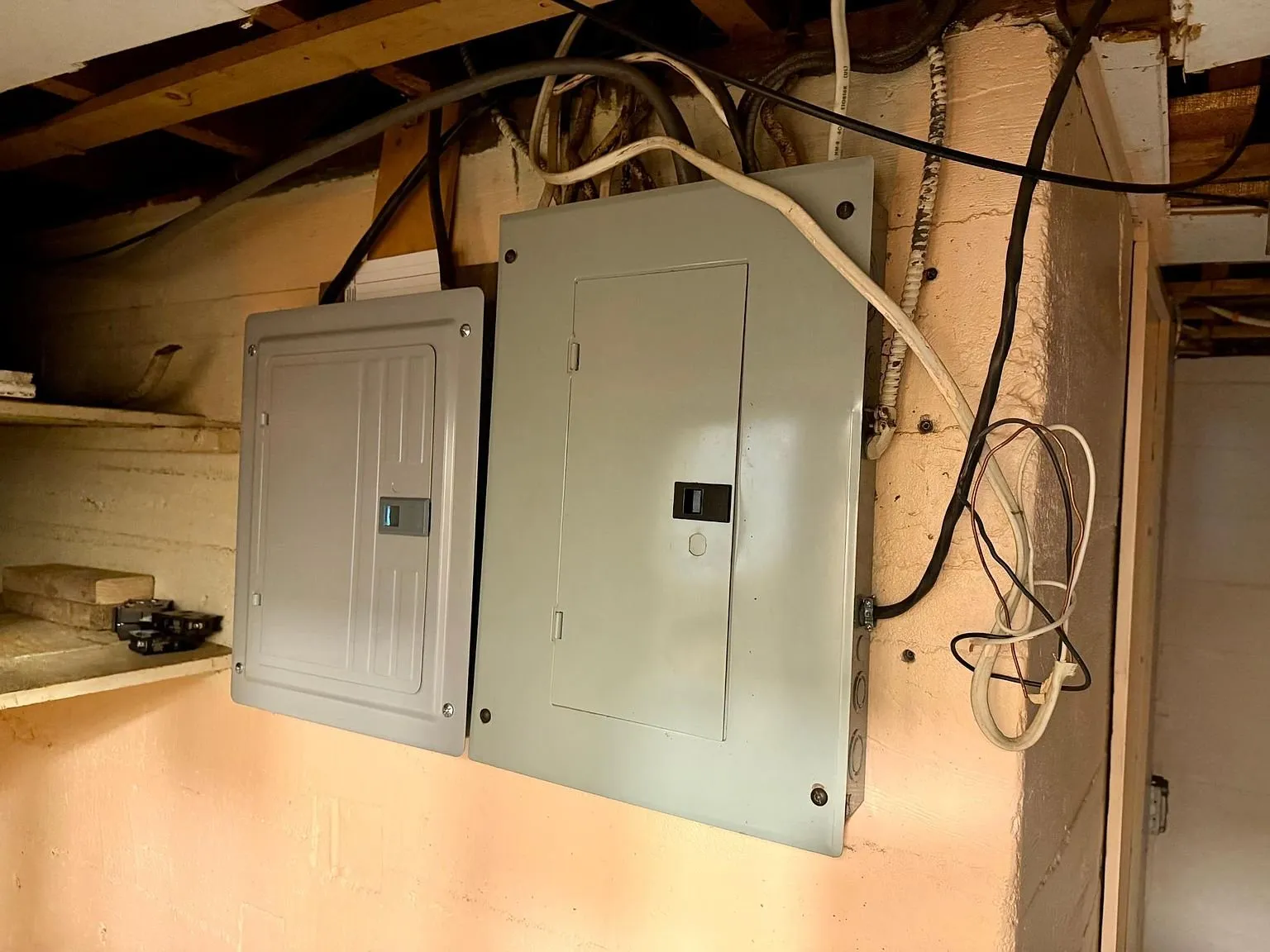 The two electrical panels on the basement wall