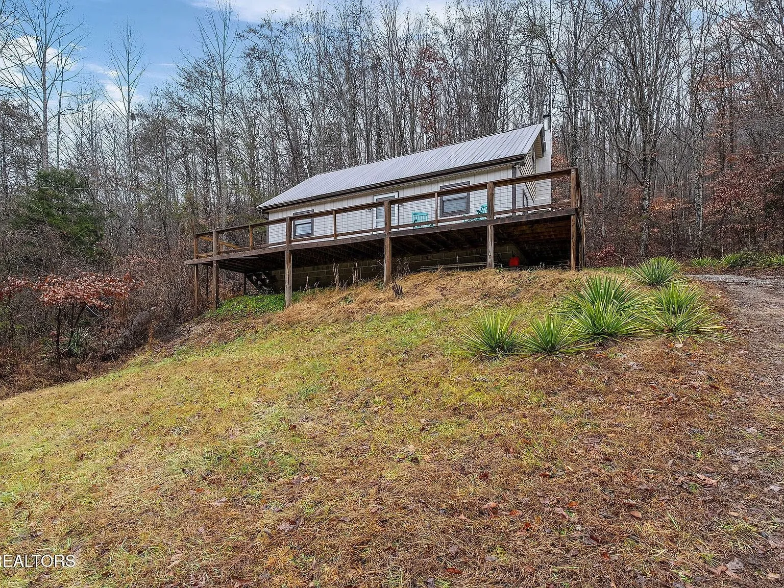 The home's gravel approach curving past the hillside
