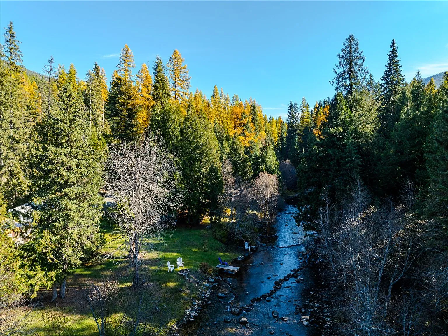 An aerial view of the creek curving past the property's open meadow