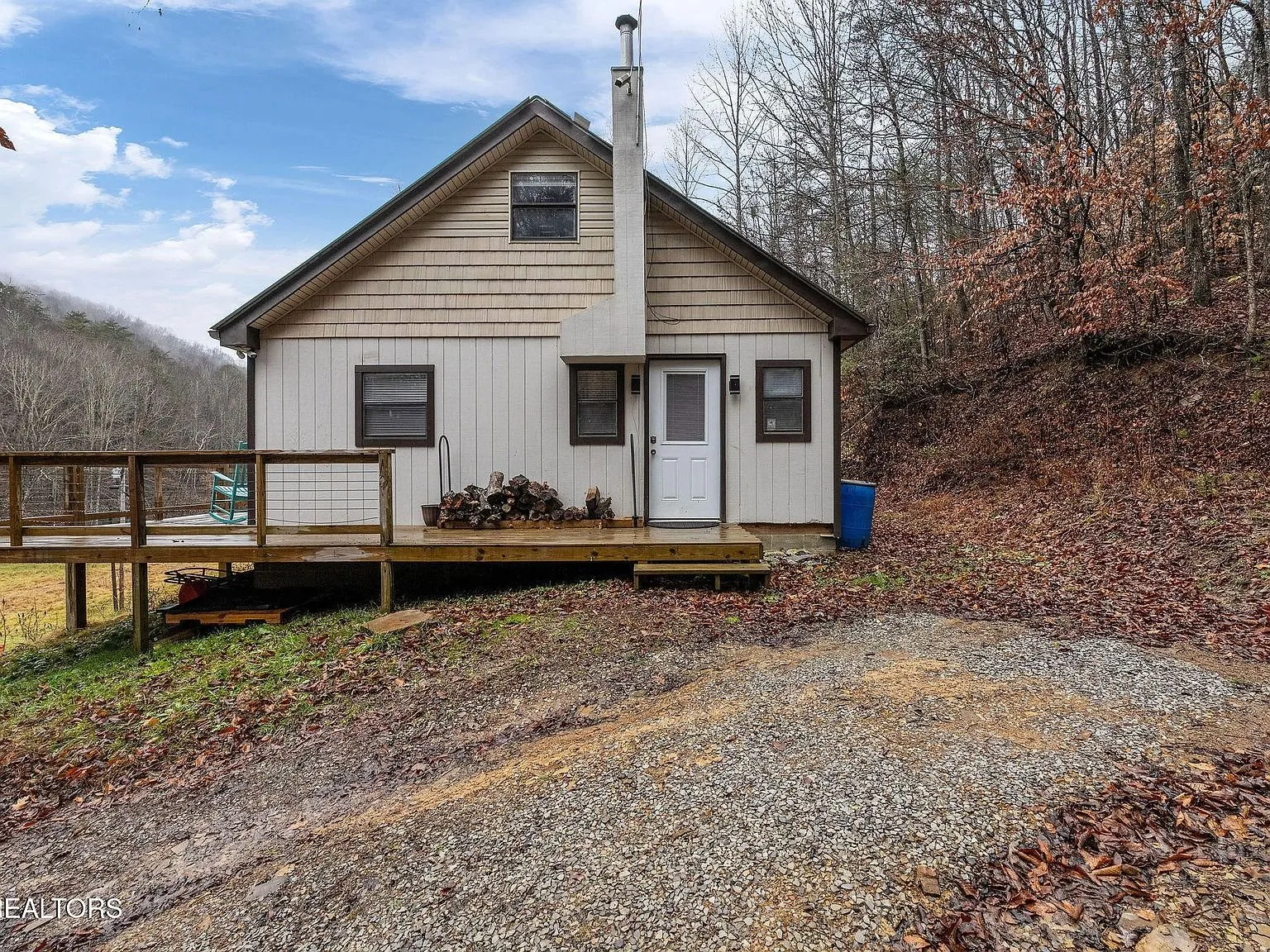 The back of the home with its utility connections and propane tank