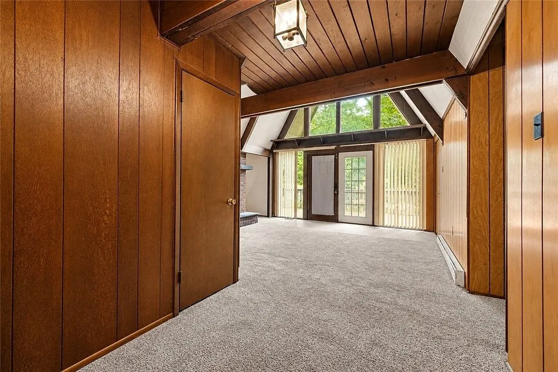 A third bedroom, empty, with a window and baseboard heat