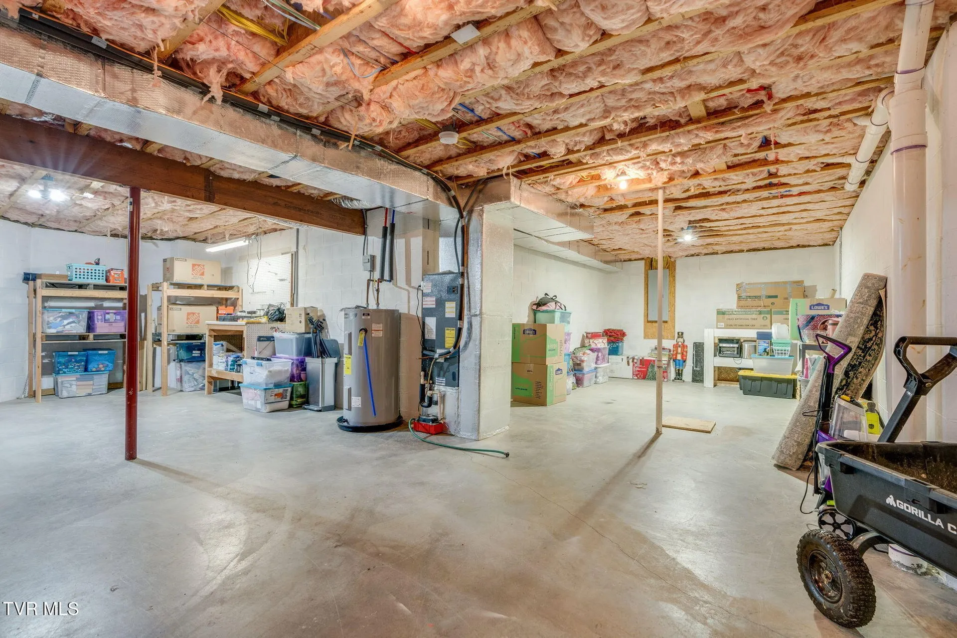 The unfinished basement and workshop area with the water heater and open joists