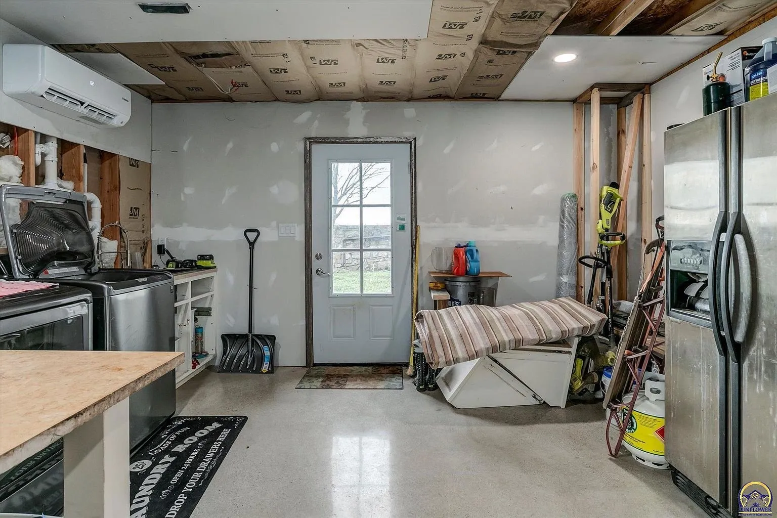 The utility room with the mini-split, the door to the yard and the refrigerator