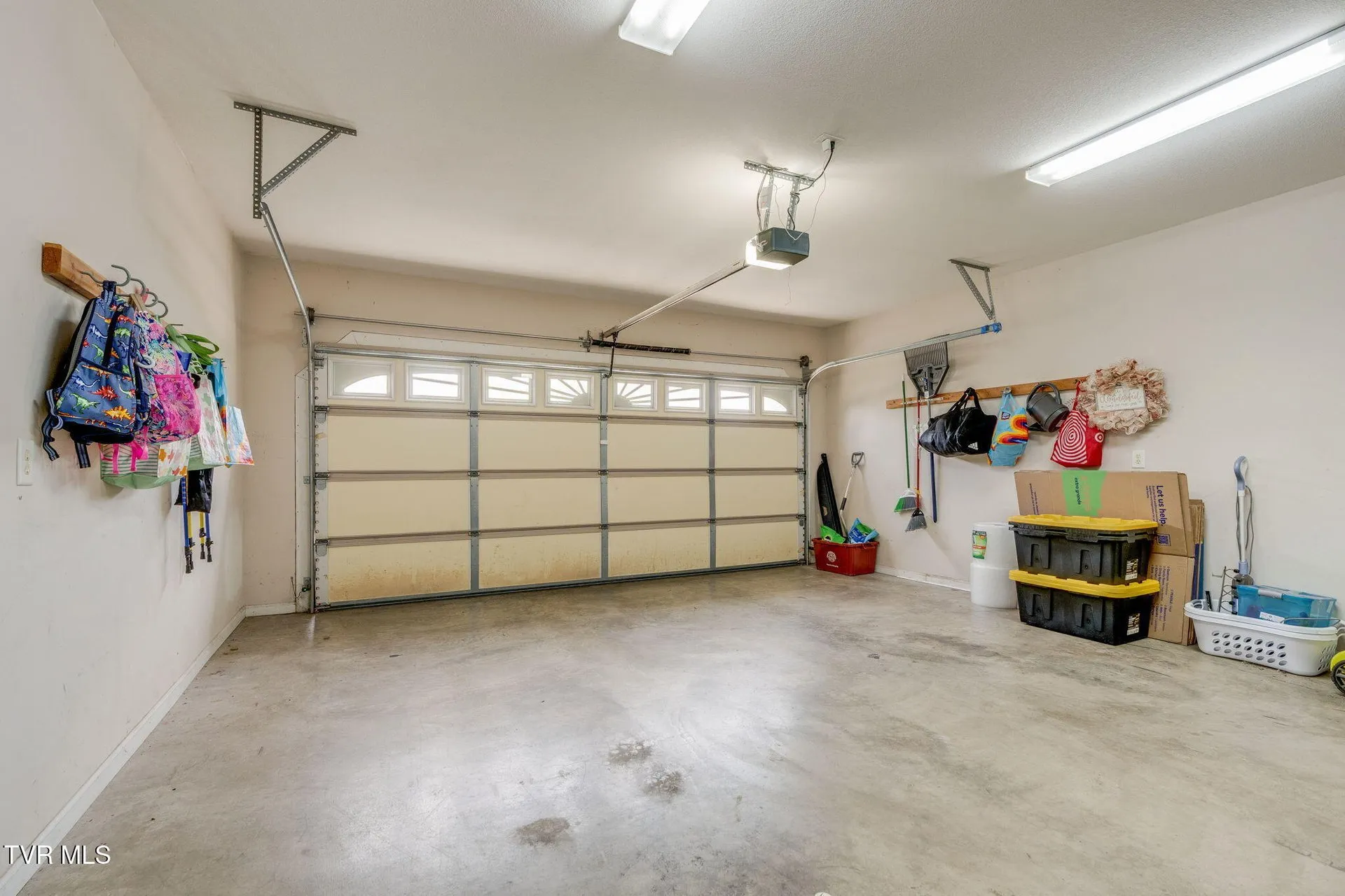 The two-car garage from inside with the door opener and hanging storage