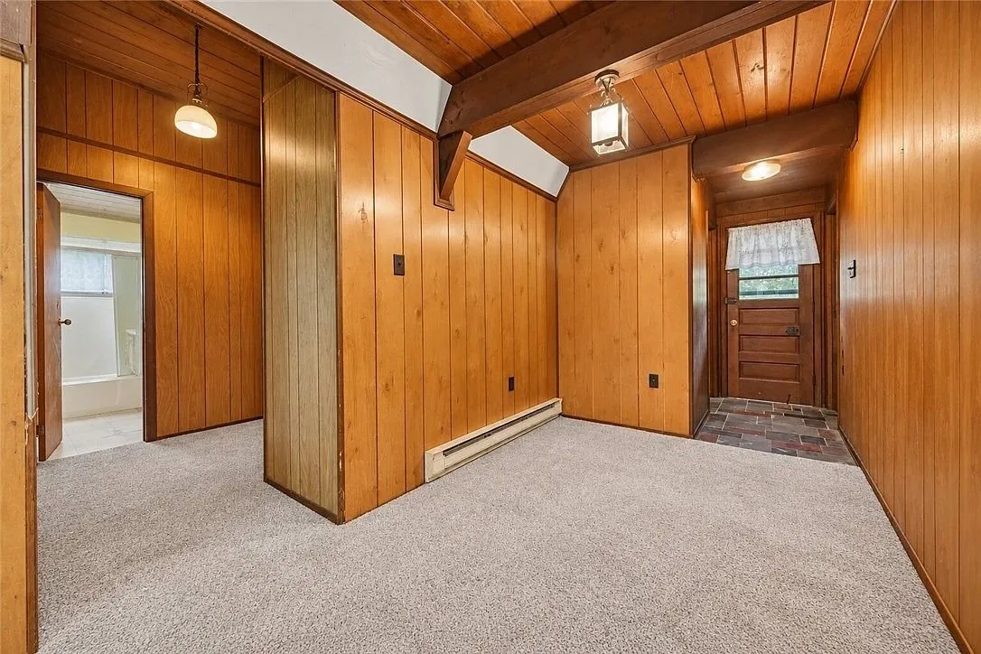 An empty room with a closet and a ceiling light