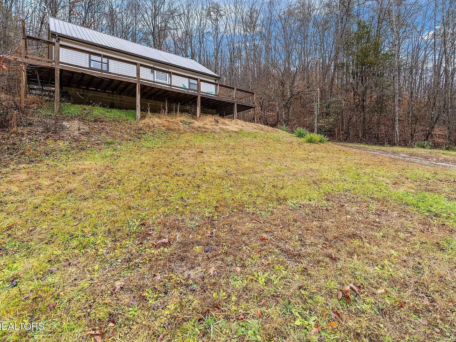 The gravel driveway looping near the house on the hillside