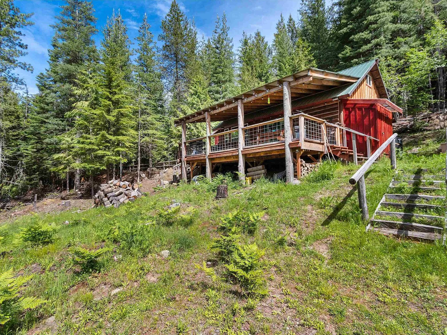 A distant aerial view of the cabin's clearing within the surrounding national forest