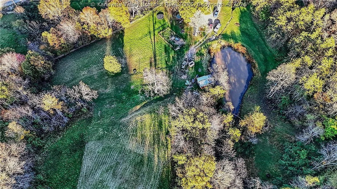An aerial view of the property's open pasture and fenced garden plot