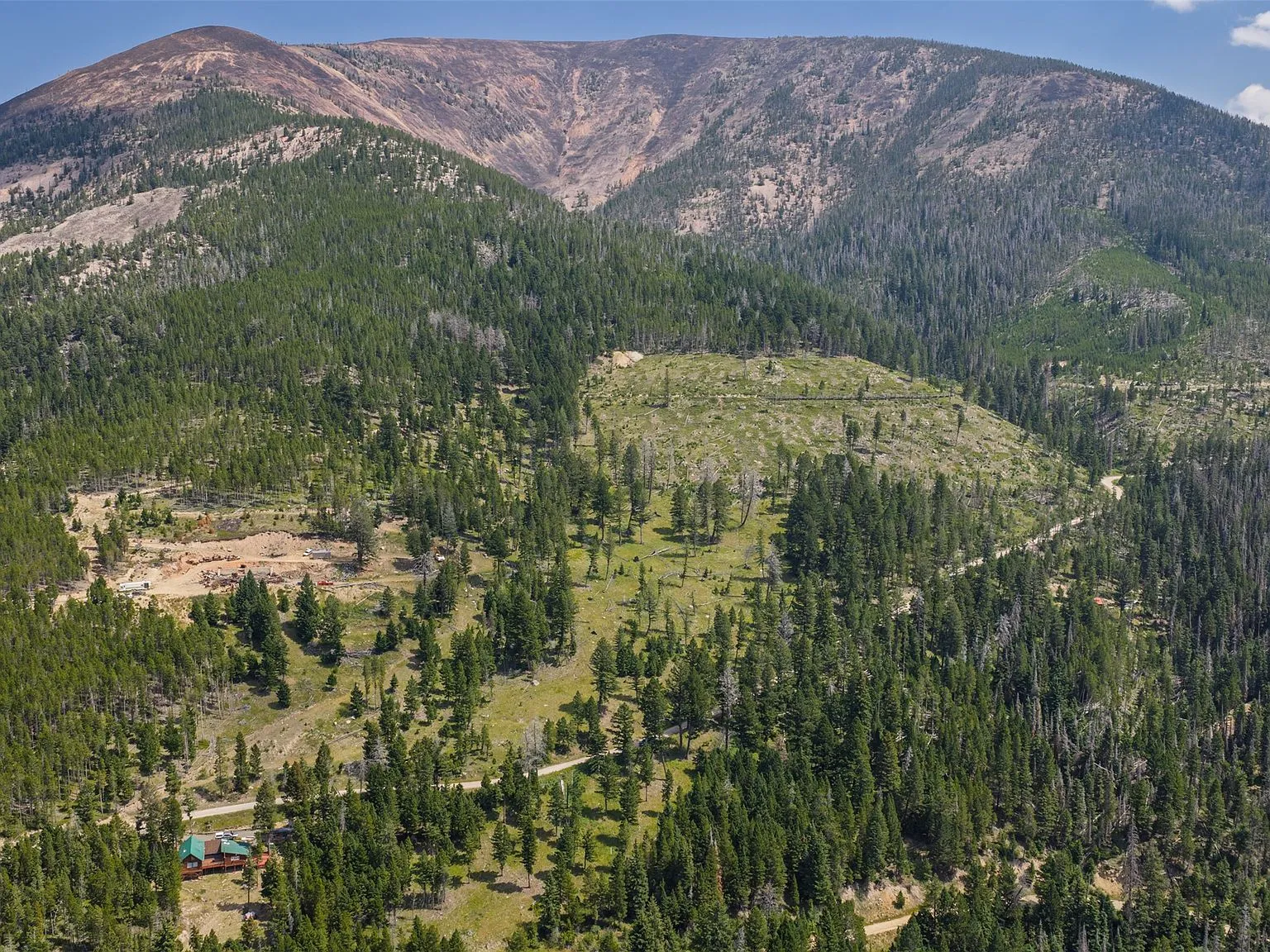 An aerial view of the A-frame cabin's gable end and stone foundation