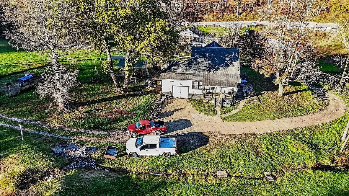 An aerial view of the house's rear addition, porch and two parked trucks