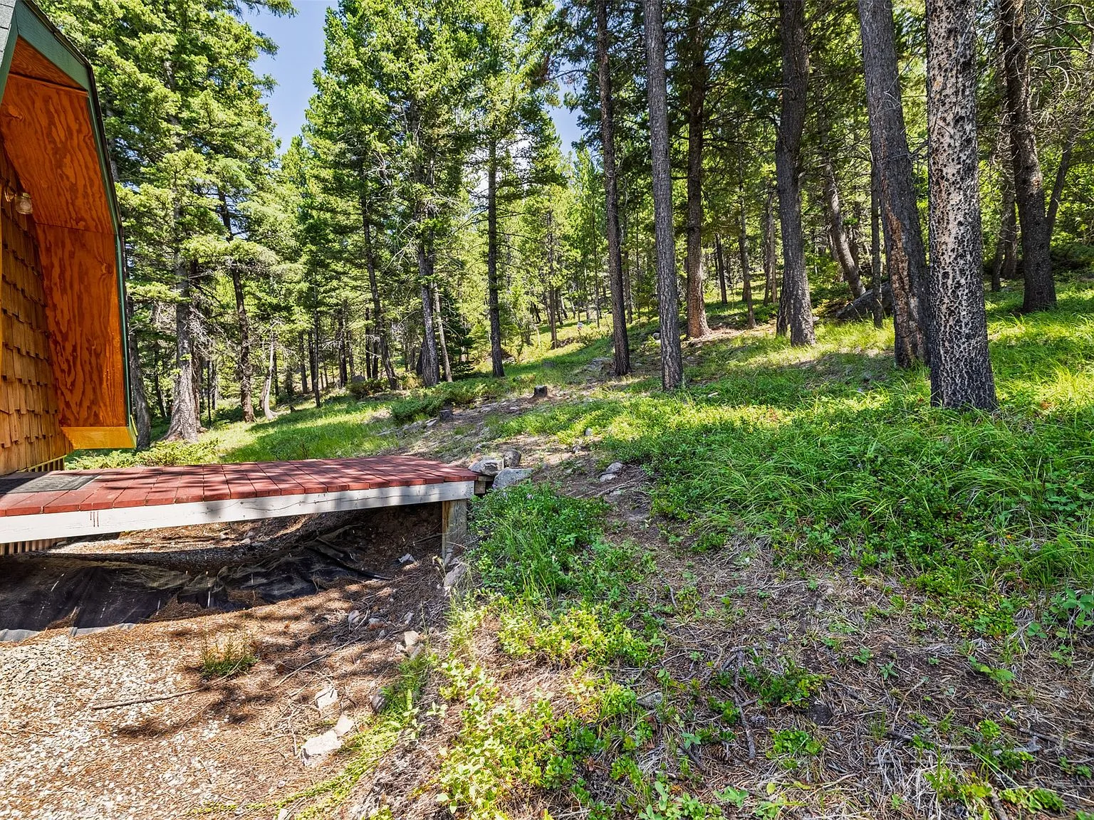 The woodshed's stacked firewood, seen from the trail above