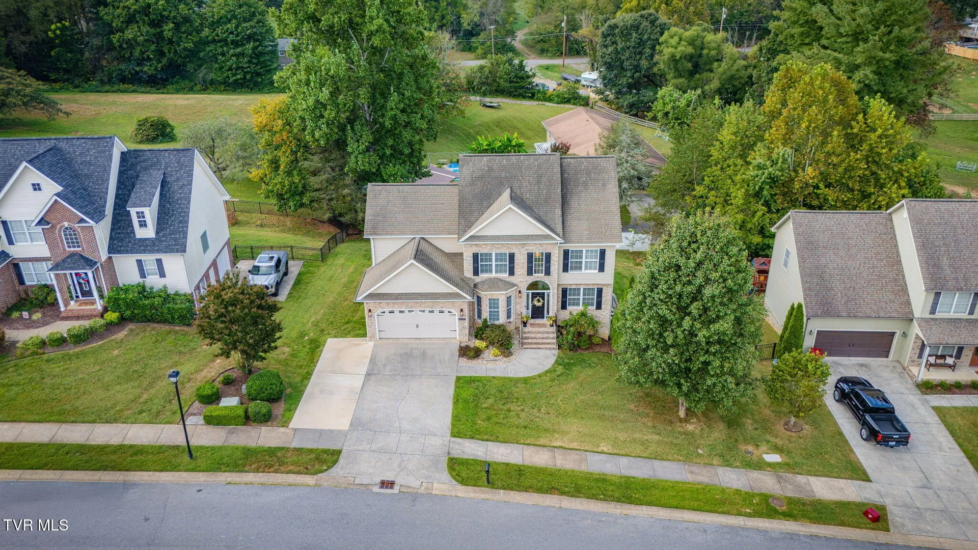 The house and neighboring homes from the air with the street in front