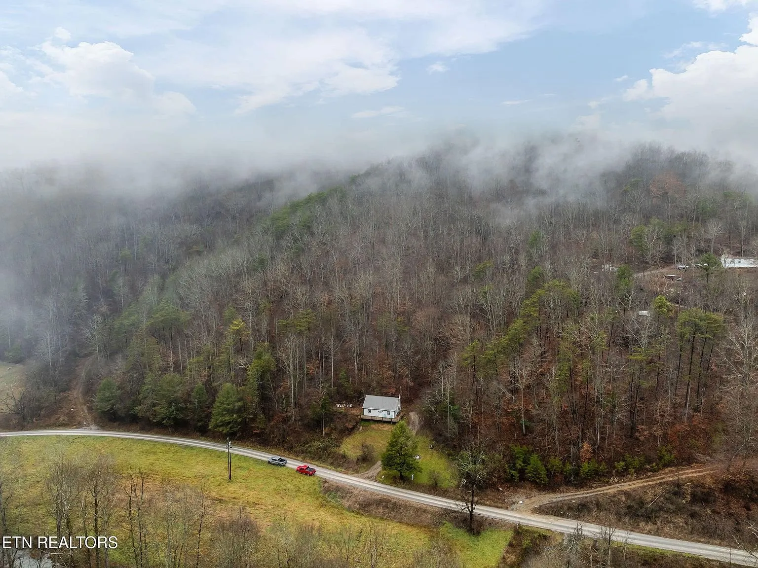 Aerial view of the home's rooftop nestled into the forested hillside
