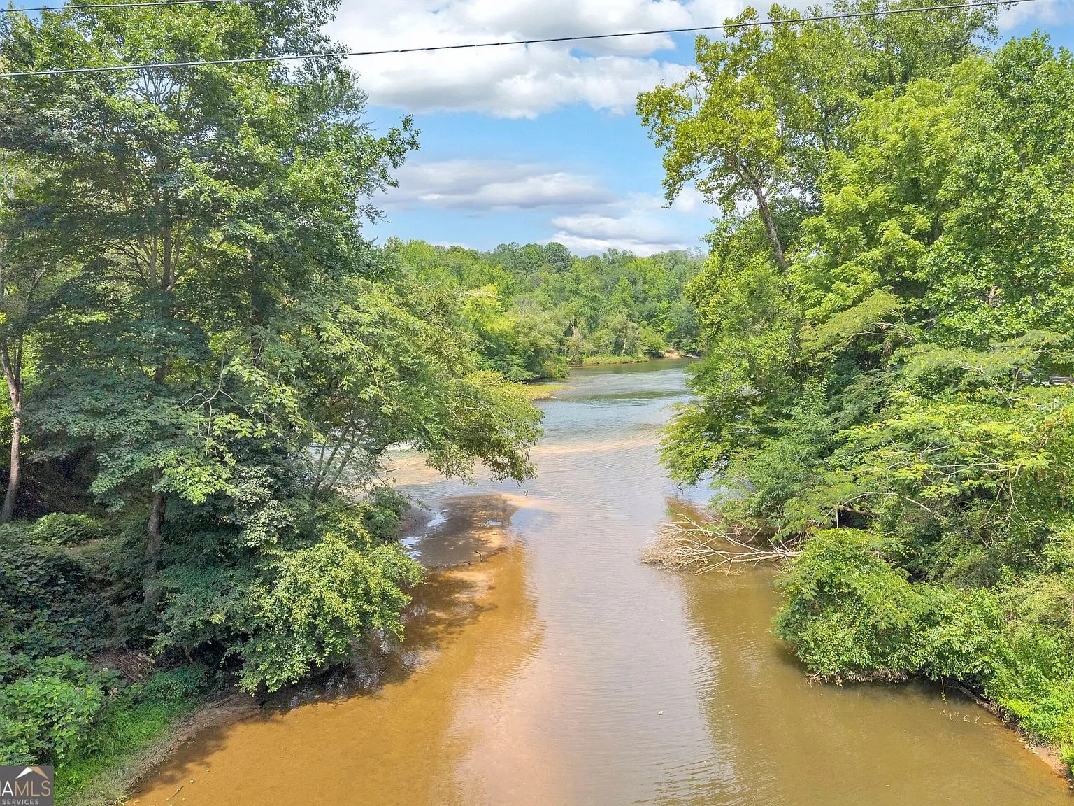A deck chair positioned to look out over the creek through the trees