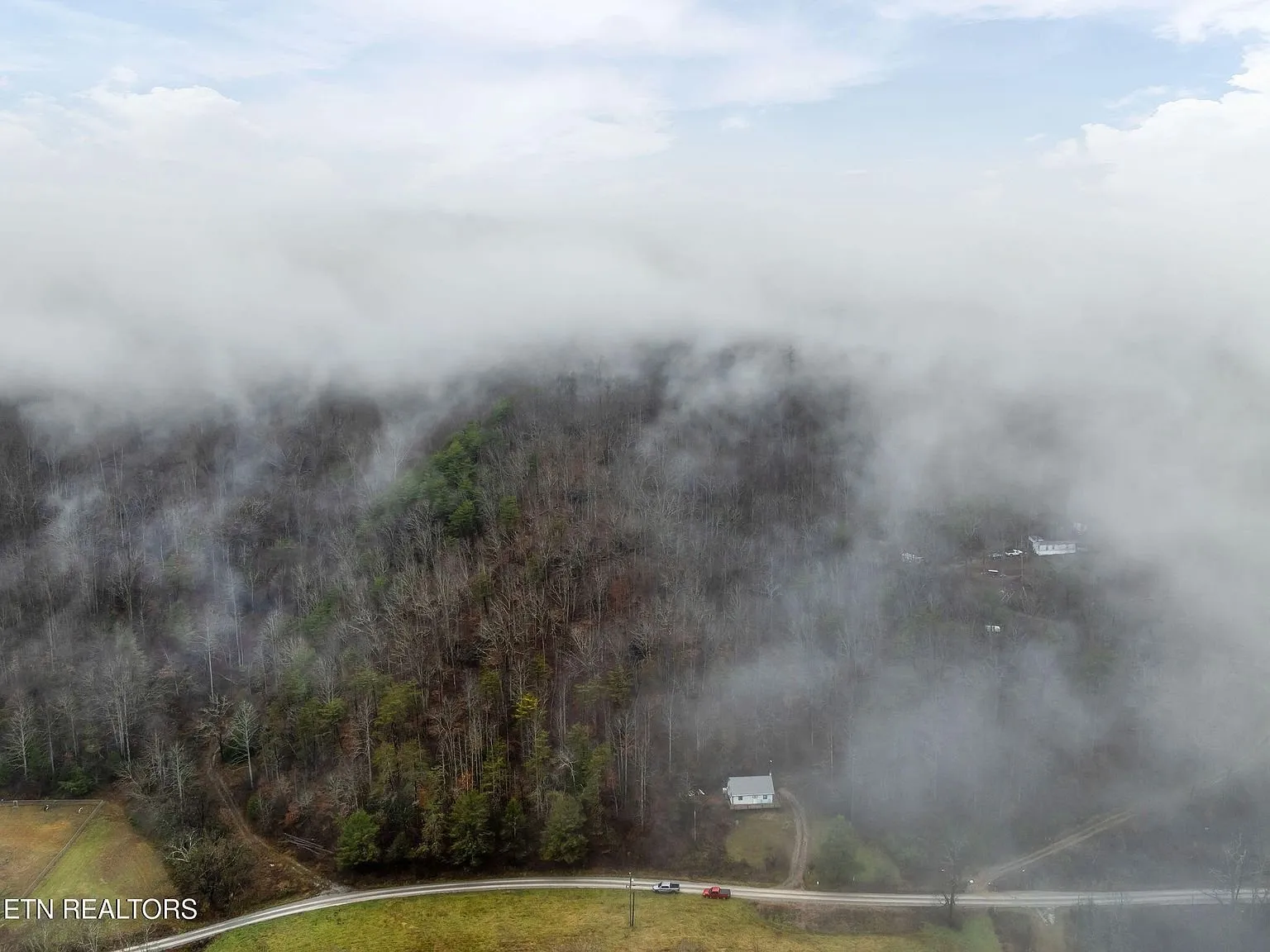 Aerial view of the ridge and tree line fading into low clouds