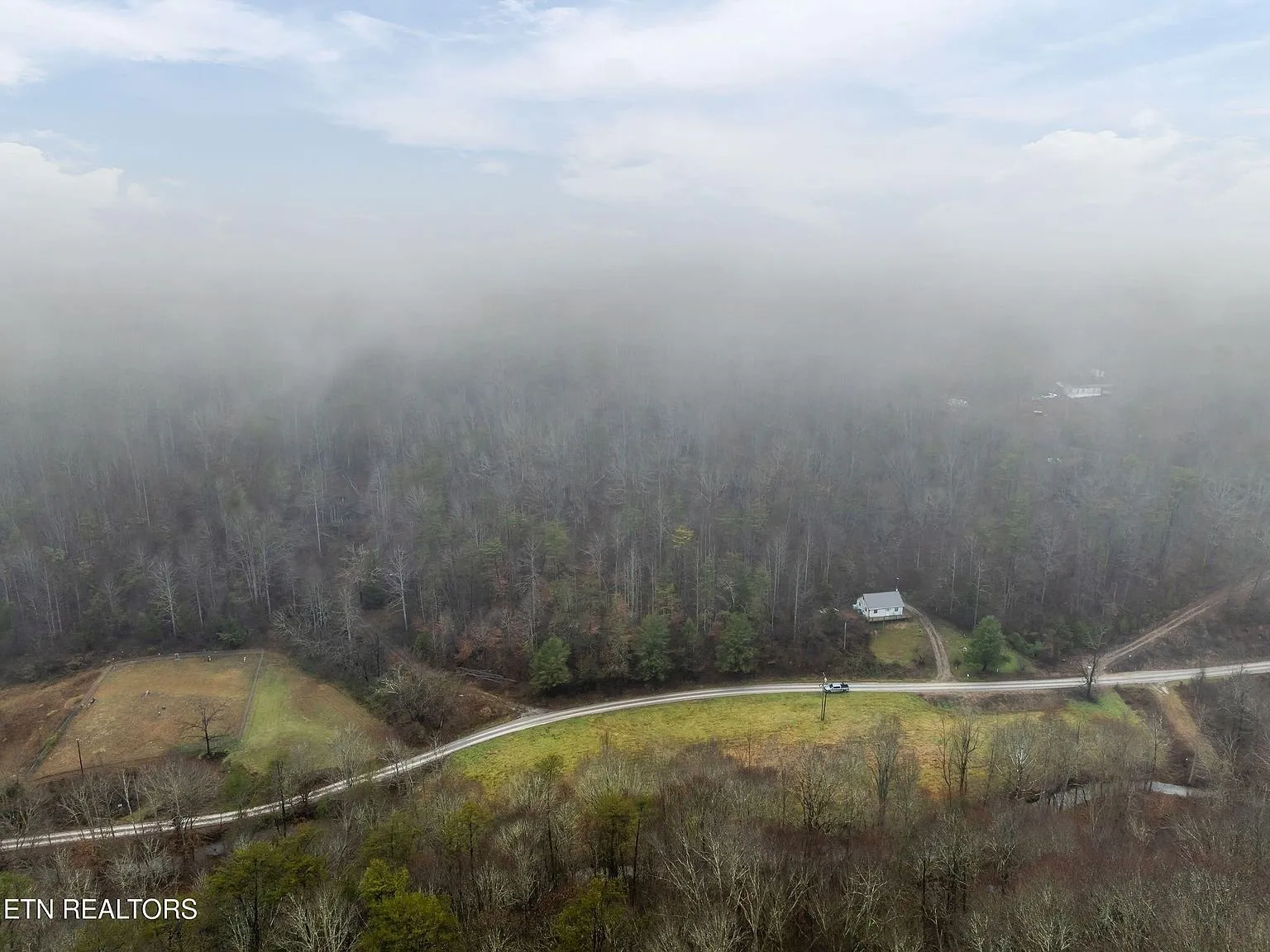 A wide aerial view of the mountain ridgeline under thick cloud cover