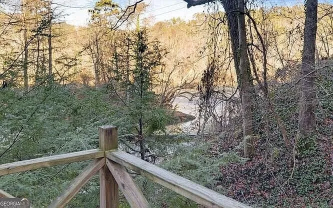 A view down toward the creek through bare winter trees from the deck railing