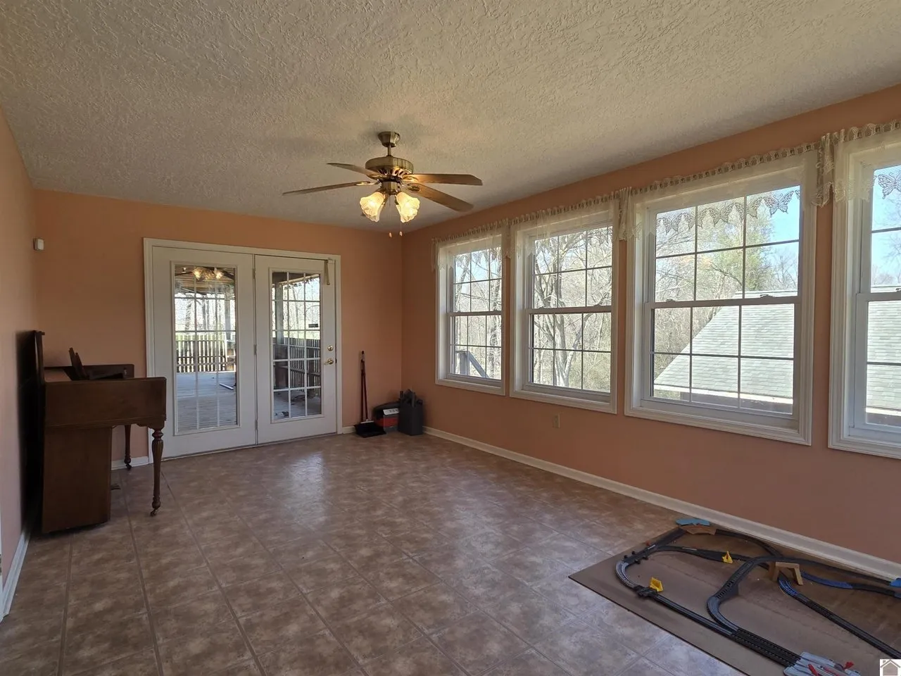The sunroom, windows on two sides and a door to the porch