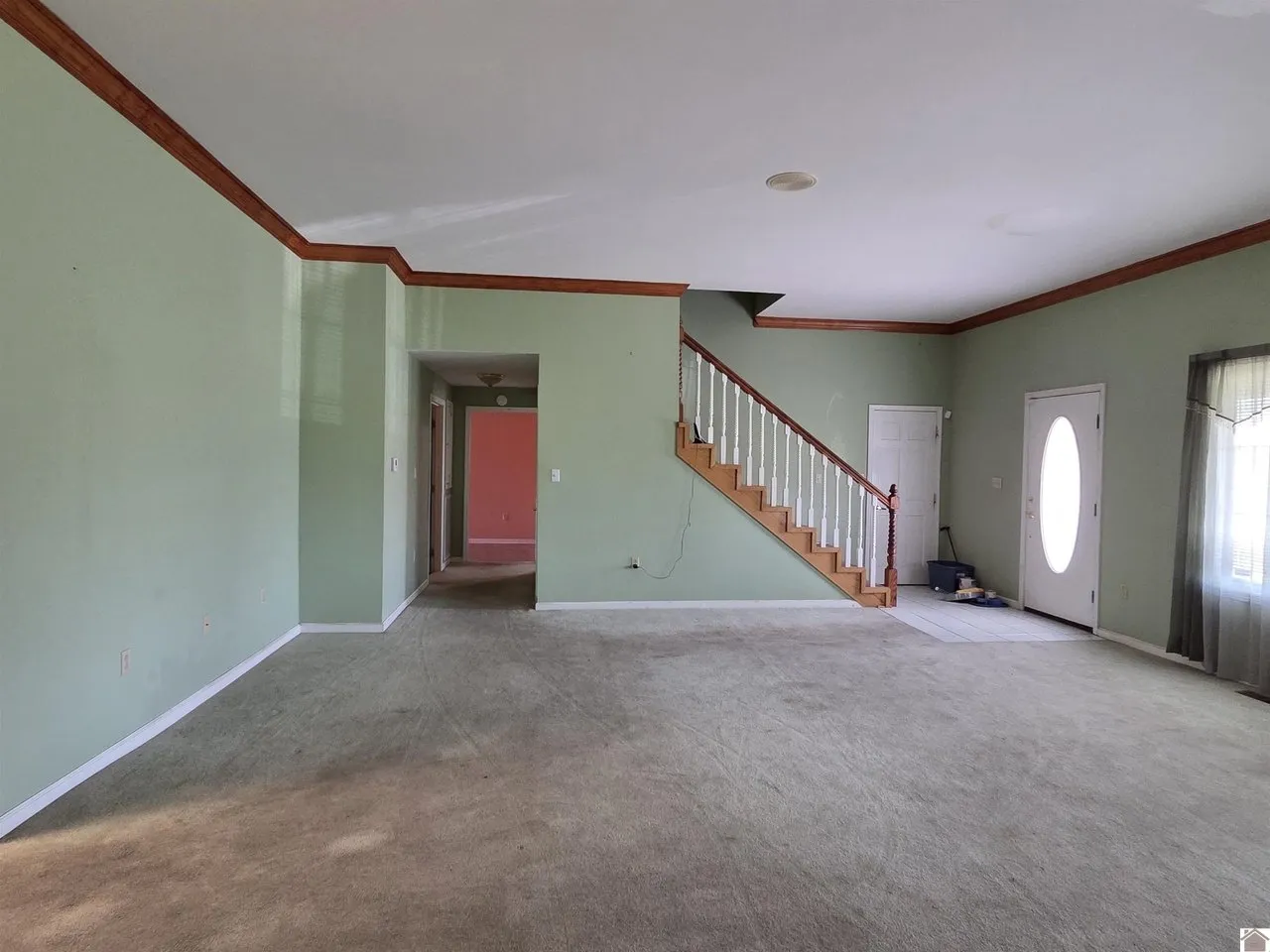 The living room with the staircase and the front door