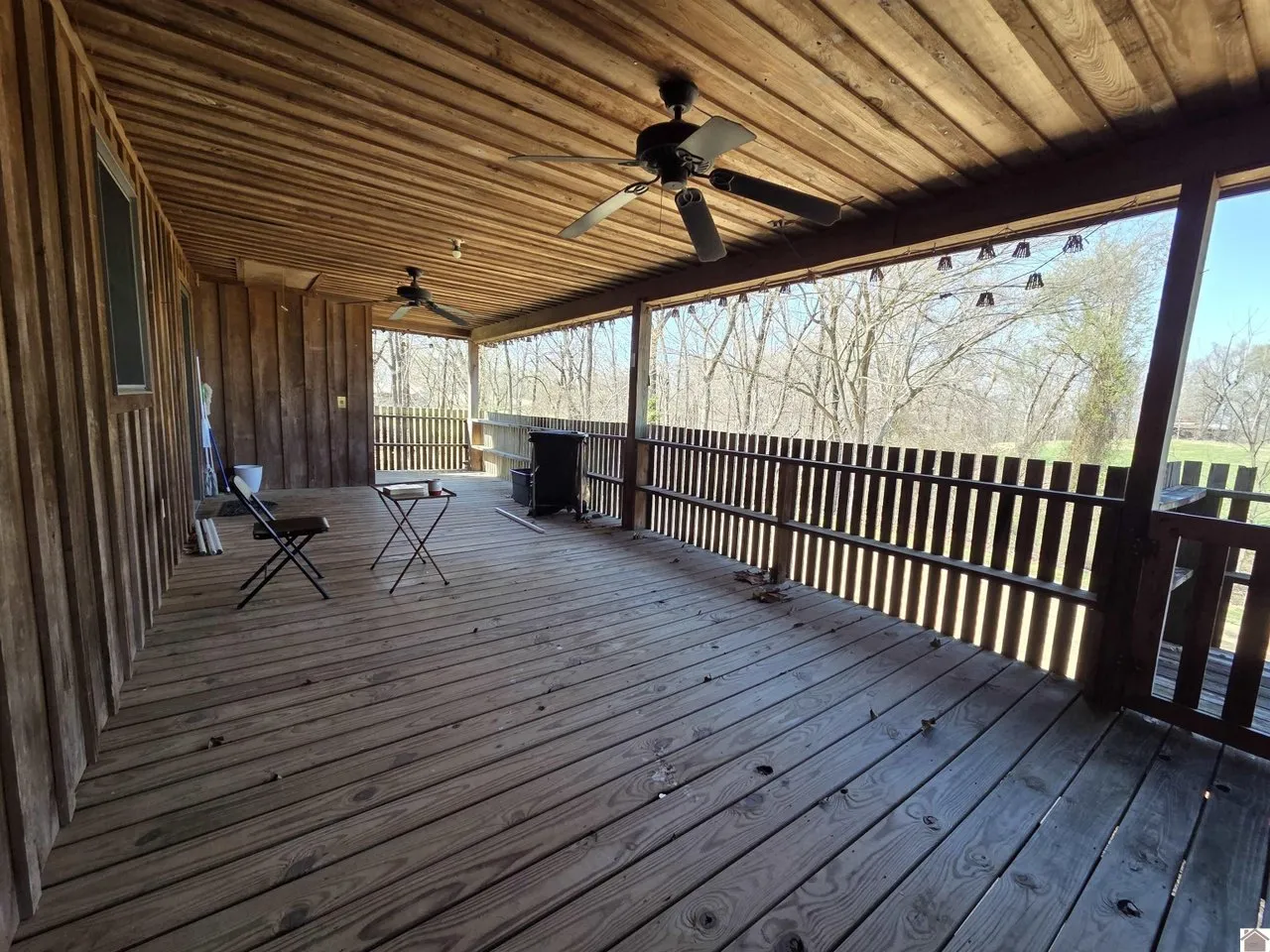 The covered porch with a ceiling fan, looking out over the fields