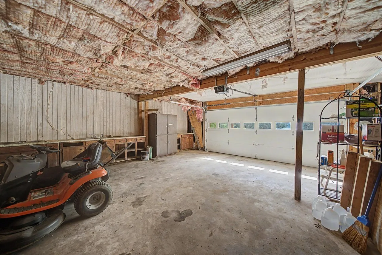 The basement garage with room for vehicles and a mower