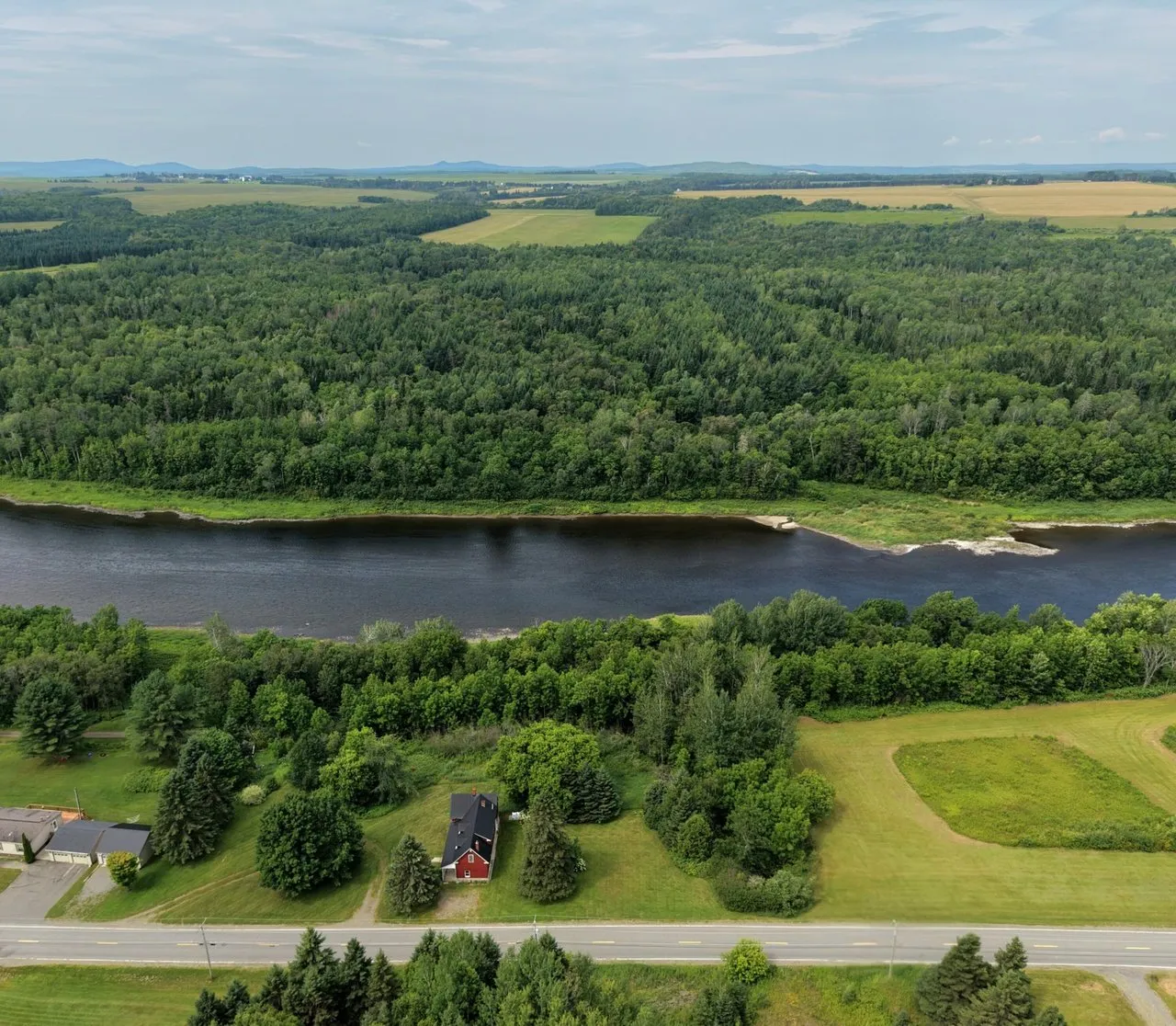 Aerial of the Aroostook River curving through farmland and woods in northern Maine