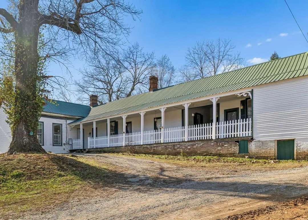 The historic farmhouse's wraparound porch and picket fence